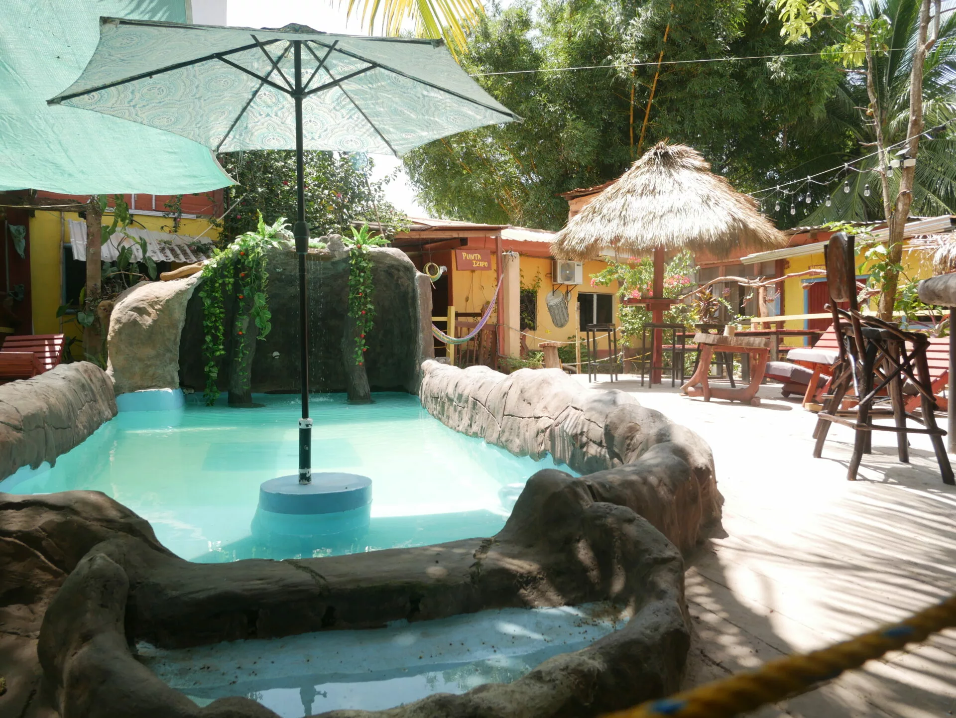 Area de piscina y restaurante de la cabaña en Tela